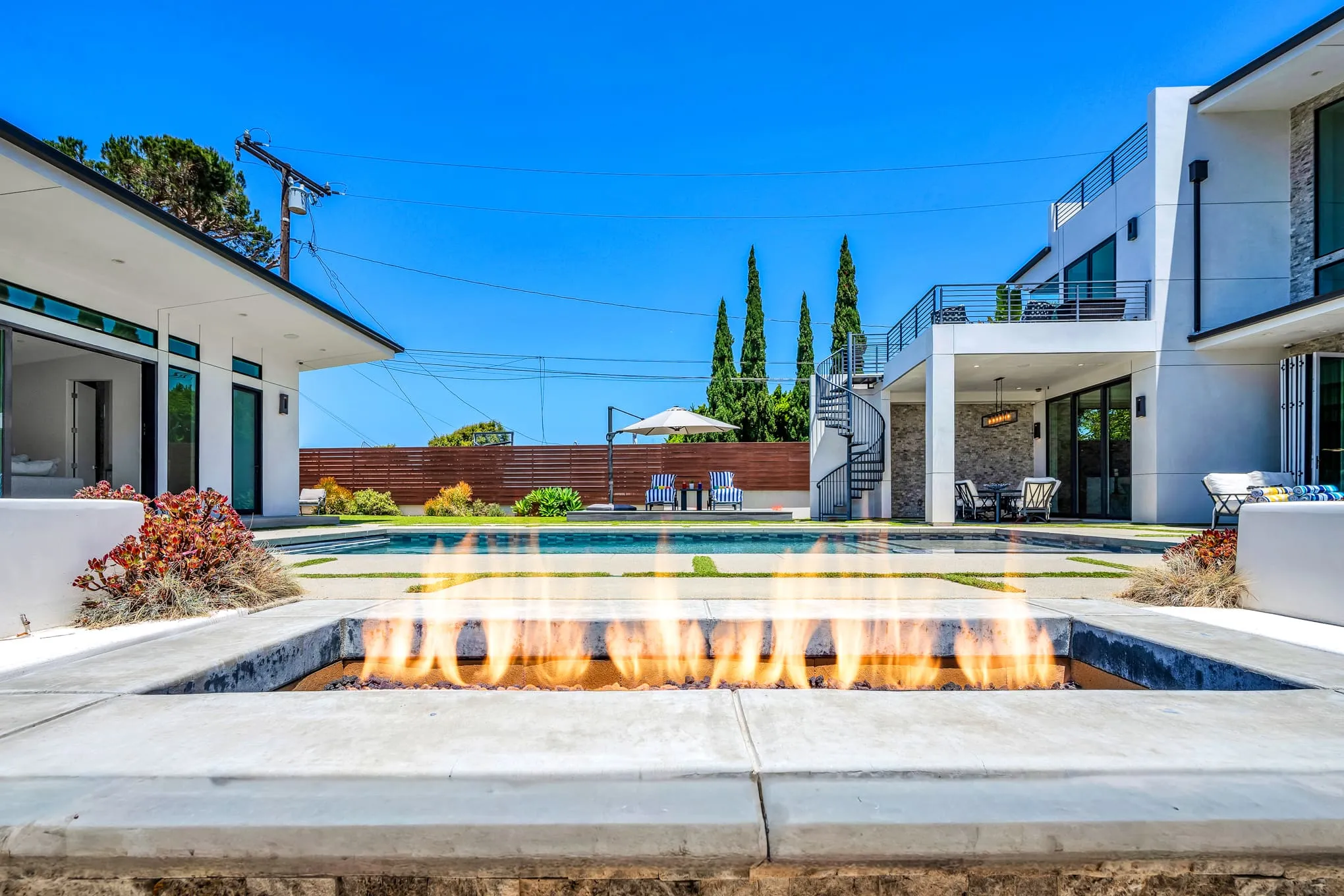 Pool with a lit fire feature at dusk
