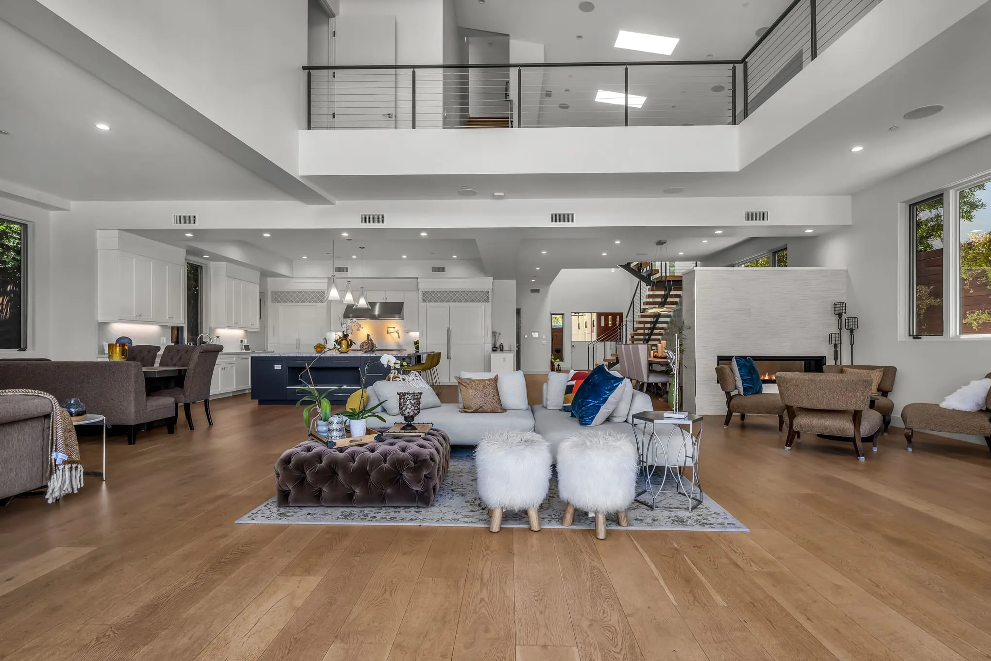 Double-height open-concept great room opening to the backyard through walls of glass