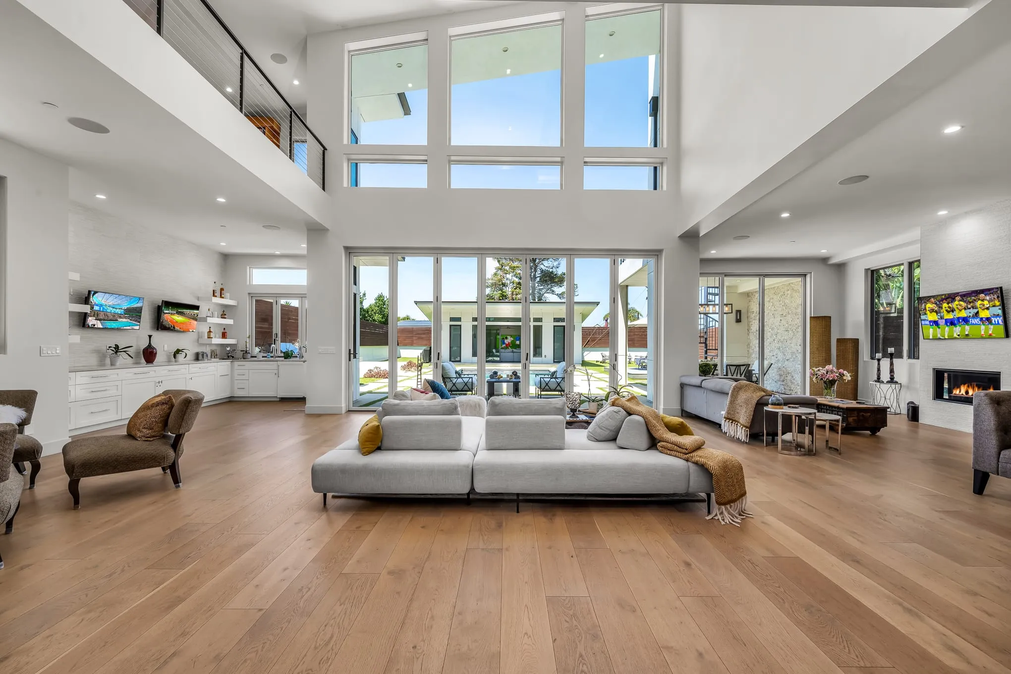 The great room opening through walls of glass to the pool and backyard